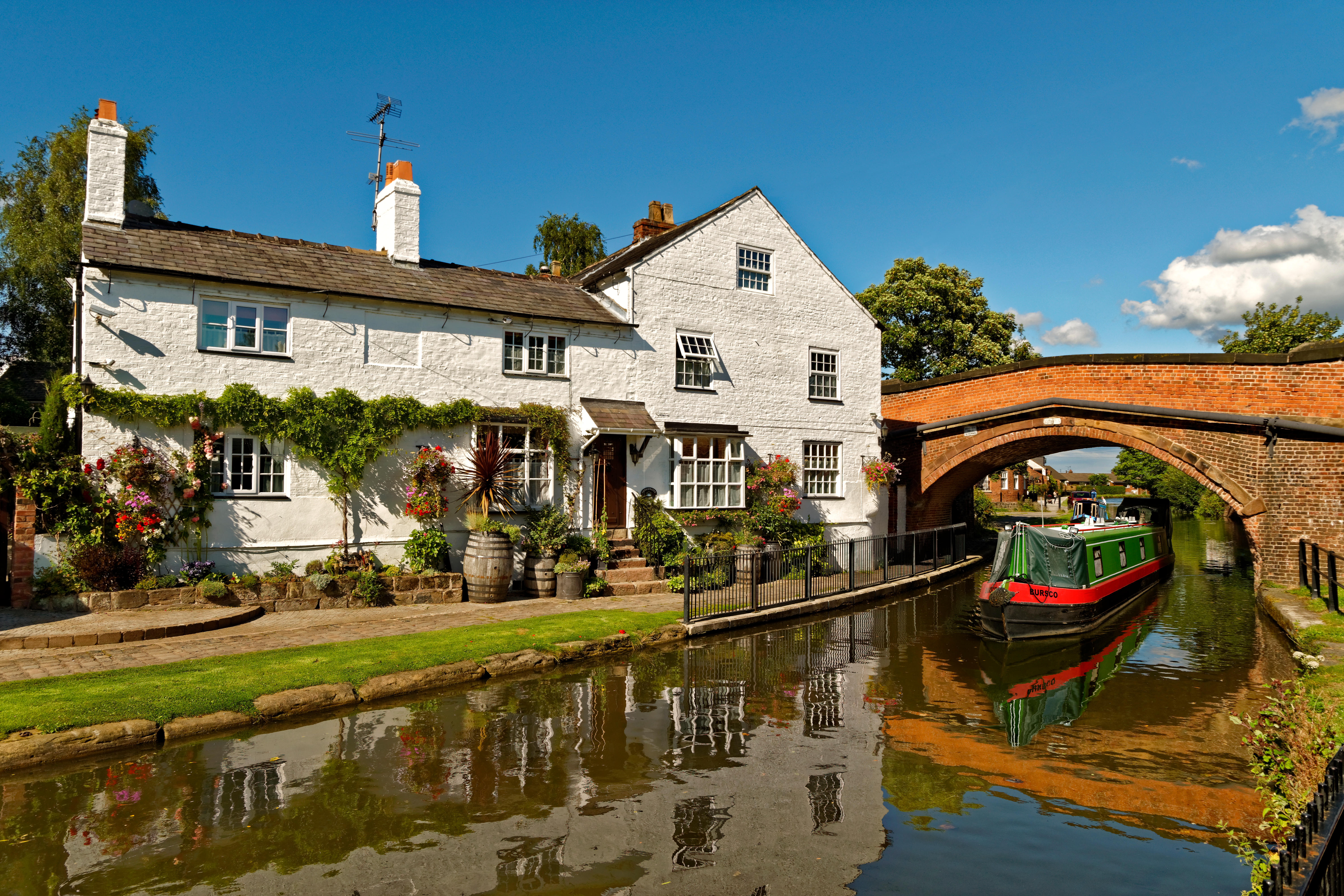 A narrowboat passing under a bridge at Lymmon the Bridgewater canal which connects Manchester, Runcorn and Leigh